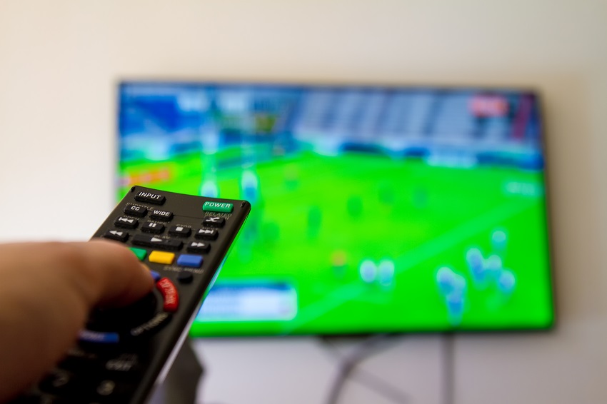 A remote control in front of a TV screen