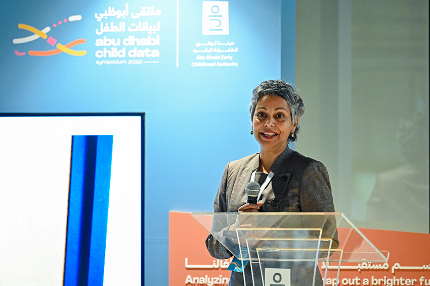 Professor Rhema Vaithianathan speaking at a lecturn in Abu Dhabi