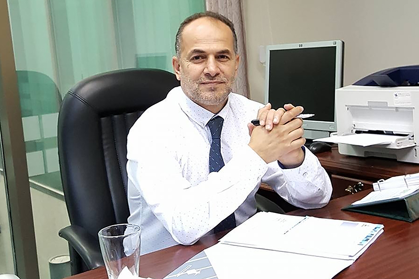Language interpreter Dr Mustafa Derbashi sitting at a desk.